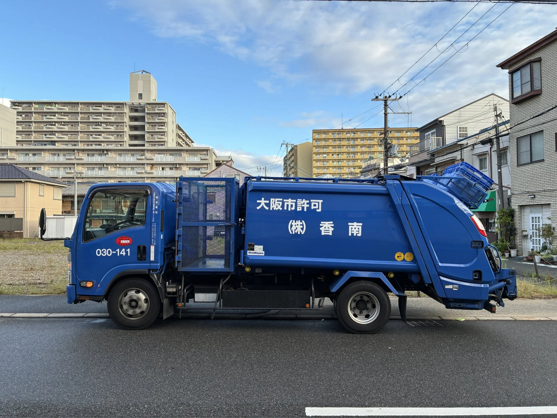 大阪市許可の表記がある株式会社 香南の青い収集車